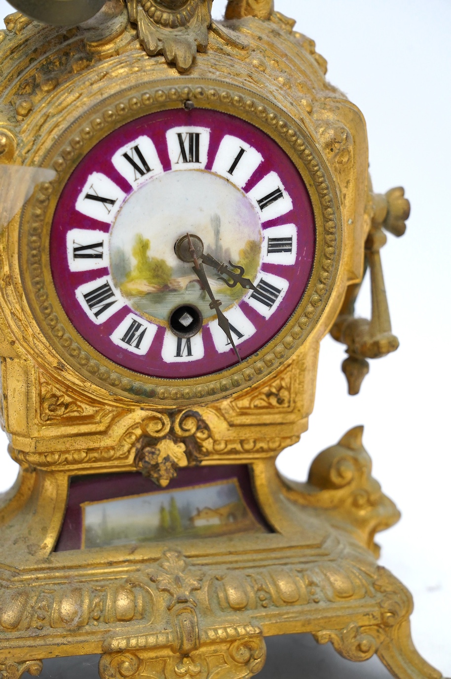 A 19th century gilt spelter mantel clock, with ceramic decorated dial and panel, 30cm high. Condition - not checked if in working condition, case fair